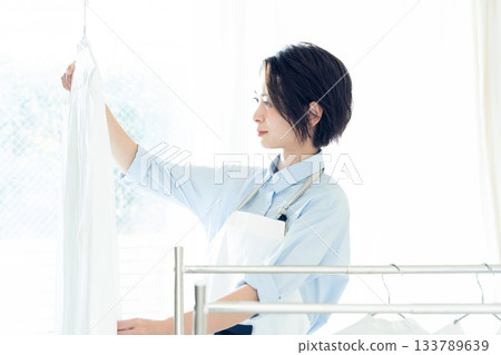 年輕的女士掛洗衣 133789639