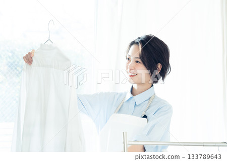 年輕的女士掛洗衣 133789643