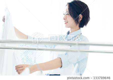 年輕的女士掛洗衣 133789646
