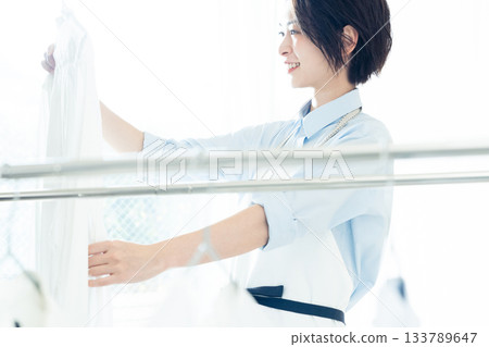 年輕的女士掛洗衣 133789647