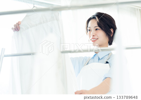 年輕的女士掛洗衣 133789648