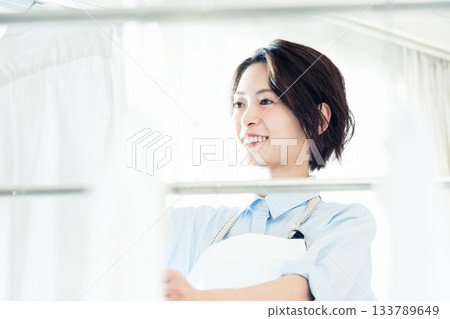 年輕的女士掛洗衣 133789649