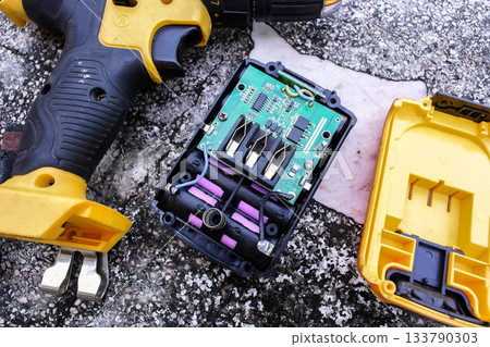 Disassembled cordless drill battery pack showing the circuit board and lithium-ion cells, 133790303