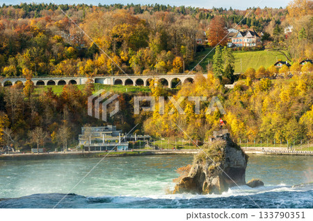 Autumn walkway and colorful trees at the Rhine Falls, Neuhausen, Schaffhausen, Switzerland 133790351