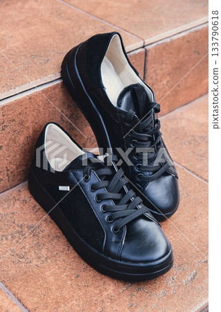 Elegant black leather womens shoes blank product for branding displayed. New casual female sneakers no-brand footwear e-commerce. No logo product 133790618