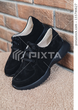 Elegant black leather womens shoes blank product for branding displayed. New casual female sneakers no-brand footwear e-commerce. No logo product 133790627