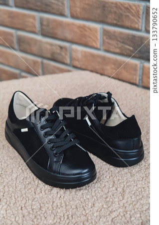 Elegant black leather womens shoes blank product for branding displayed. New casual female sneakers no-brand footwear e-commerce. No logo product 133790652