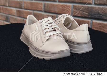 Fresh beige leather sneakers without brand marks displayed. For design templates online shops and sustainability-themed marketing. Clean blank sneakers Fresh beige leather sneakers without brand marks displayed. For design templates online shops and sustainability-themed marketing. Clean blank sneakers 133790656