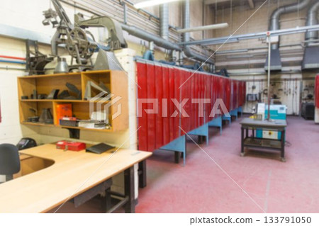 Flat design showing metal workshop with red welding curtains, desk, shelf, mobile cart, ducts 133791050