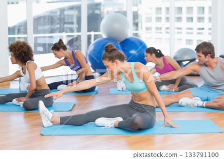 Group of adults are stretching legs on blue mats in flat design studio with stability balls 133791100