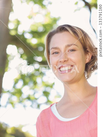 Portrait of smiling young woman against tree Portrait of smiling young woman against tree 133791160