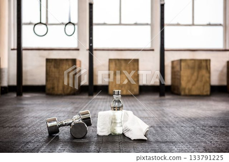 Dumbbells by bottle and napkin on floor 133791225