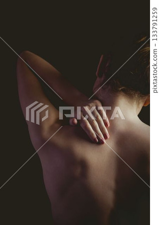 Female figure is stretching bare back in dark studio scene, 3D render emphasizing contours 133791259