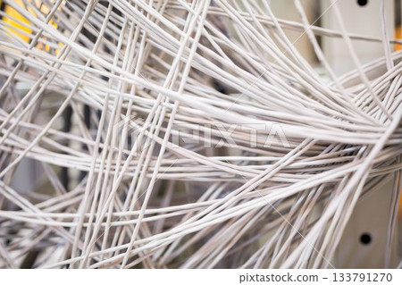 Showing tangled white network cables crossing flat design rack patch panel with metal guides 133791270