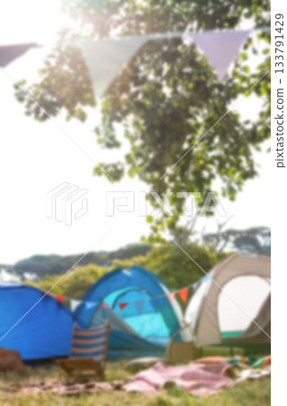 Tents by tree on grassy field Tents by tree on grassy field 133791429
