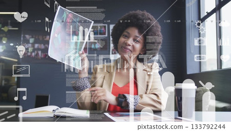 Pointing woman in beige blazer showing printed report pages at office, with digital data overlay 133792244