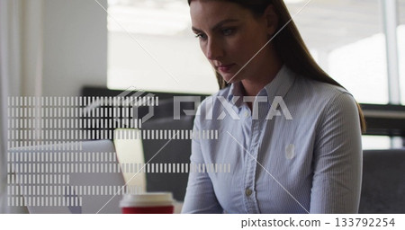 Typing woman in blue shirt working at office desk, with silver laptop, red-sleeved coffee cup Typing woman in blue shirt working at office desk, with silver laptop, red-sleeved coffee cup 133792254