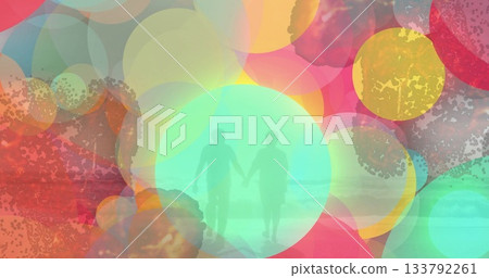 Walking senior couple holding hands on shallow sandy shore, with translucent circles over sea waves 133792261