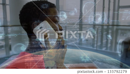 Red-shirted woman talking on phone by metal railing and panes in corridor with charts, copy space 133792279