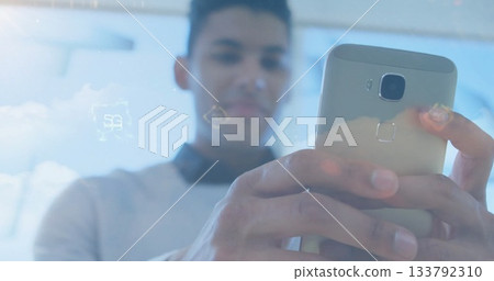 Focusing man wearing sweater and collared shirt holding smartphone in office, with holograms Focusing man wearing sweater and collared shirt holding smartphone in office, with holograms 133792310