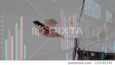 Executive tapping smartphone in meeting room in white shirt, tie, with charts, tables, copy space 133792345
