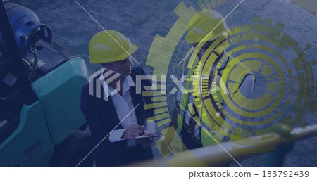 Reviewing construction duo in yellow helmets examining clipboard at jobsite with overlay graphics Reviewing construction duo in yellow helmets examining clipboard at jobsite with overlay graphics 133792439