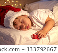 A child sleeping in anticipation of a Christmas present 133792667