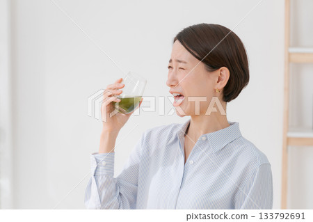 一名女子正在喝苦綠果汁 一名女子正在喝苦綠果汁 133792691
