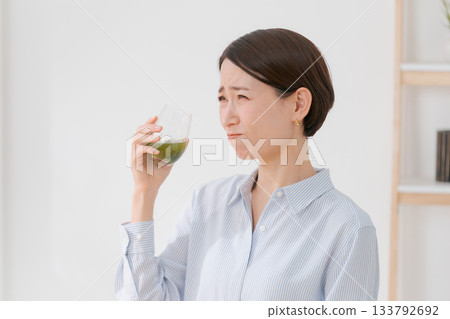 一名女子正在喝苦綠果汁 133792692