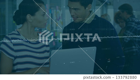 Collaborating coworkers studying laptop screen in modern open-plan office, with bright sticky notes 133792880