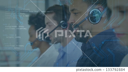 Call center agent in patterned shirt handling calls in office, headsets and monitors, copy space 133792884