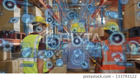 Analyzing digital overlays, workers wearing yellow hardhats and vests viewing shelves in warehouse 133793122