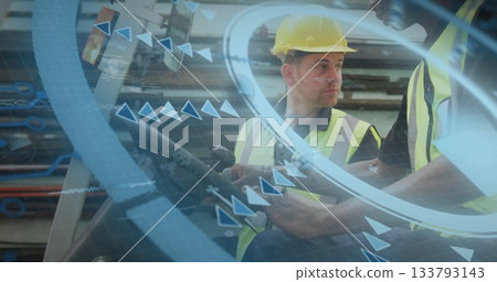 Industrial workers wearing vests and hard hats handling controls in facility, with joystick, AR 133793143