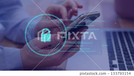 Office worker wearing blue shirt holding smartphone at desk, showing laptop, digital padlock 133793154