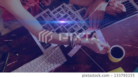 Sorting contact sheets two creatives reviewing images at studio desk, with swatches and laptop Sorting contact sheets two creatives reviewing images at studio desk, with swatches and laptop 133793155