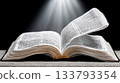 Open bible under dramatic light with turning pages 133793354