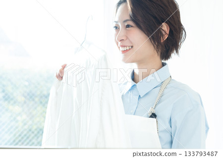 年輕的女士掛洗衣 133793487