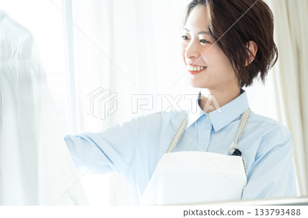 年輕的女士掛洗衣 133793488