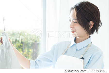 年輕的女士掛洗衣 133793489
