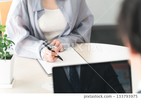 Female customer filling out a questionnaire, medical questionnaire, or counseling sheet Female customer filling out a questionnaire, medical questionnaire, or counseling sheet 133793975