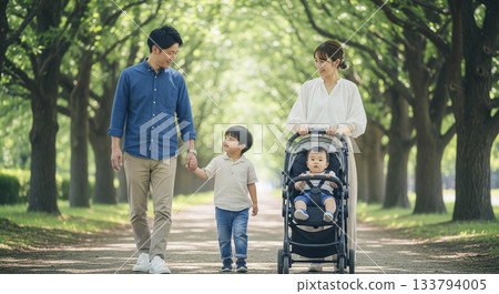一家四口沿著綠樹成蔭的小路散步。 133794005