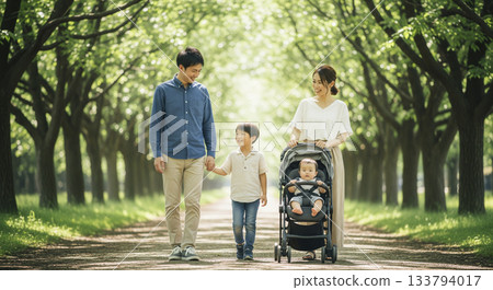 一家四口沿著綠樹成蔭的小路散步。 133794017