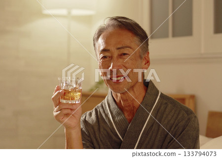 Senior man drinking whiskey in his bedroom Senior man drinking whiskey in his bedroom 133794073