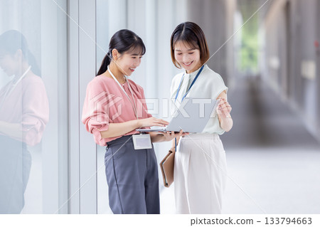 一位職業婦女正在開會，同時看著電腦。 133794663