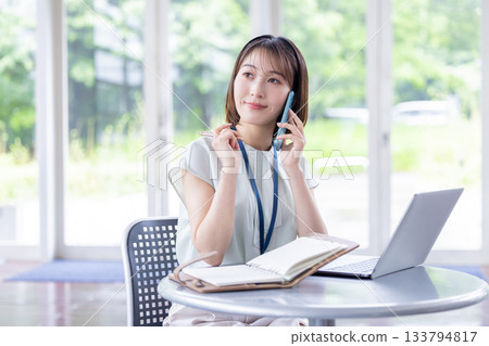 一位女商人正在用她的智慧型手機打電話 一位女商人正在用她的智慧型手機打電話 133794817