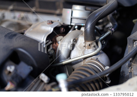 Close-up of car turbocharger system showing engine detail, metal texture, and automotive technology concept Close-up of car turbocharger system showing engine detail, metal texture, and automotive technology concept 133795012