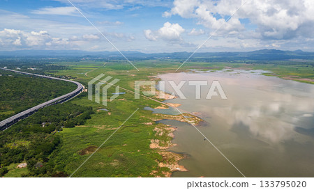 A wide aerial shot of Lam Takhong reservoir surrounded by hills and greenery in Nakhon Ratchasima. The scenic water source blends nature, infrastructure, and regional beauty 133795020