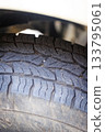 Closeup of a four-wheel drive pickup truck all-terrain tire showing worn tread patterns, dirt, and signs of rugged off-road use 133795061