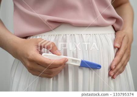 Asian holding pregnancy test for female of ovulation day, fetus, maternity, childbirth, birth control. Asian holding pregnancy test for female of ovulation day, fetus, maternity, childbirth, birth control. 133795374