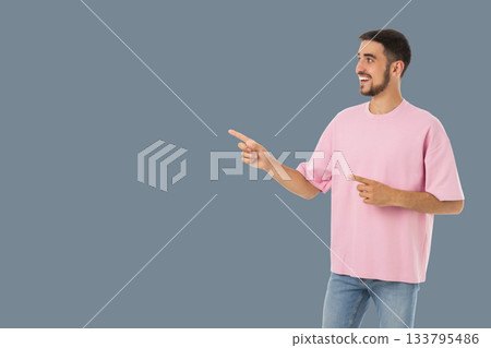 Man dressed casually in a pink shirt happily gestures to the side Man dressed casually in a pink shirt happily gestures to the side 133795486